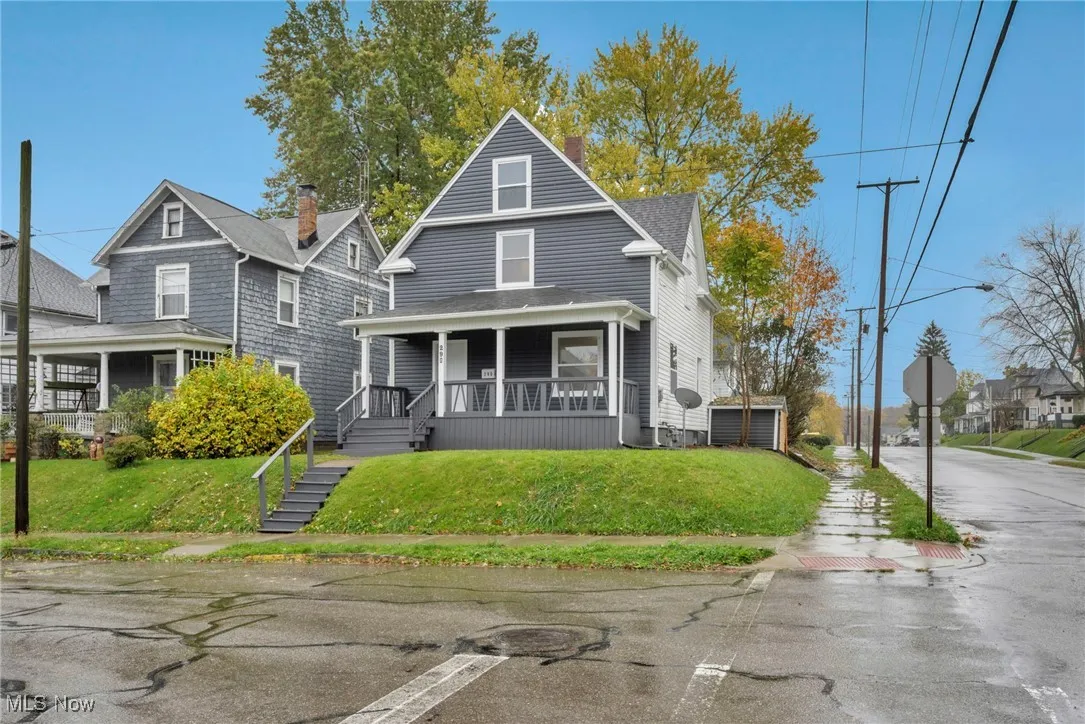 Traditional style home with covered porch and a front lawn