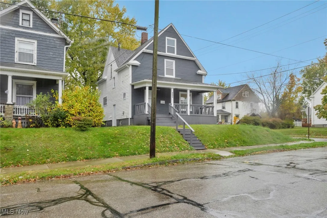 Traditional style home with covered porch, a chimney, and a front yard