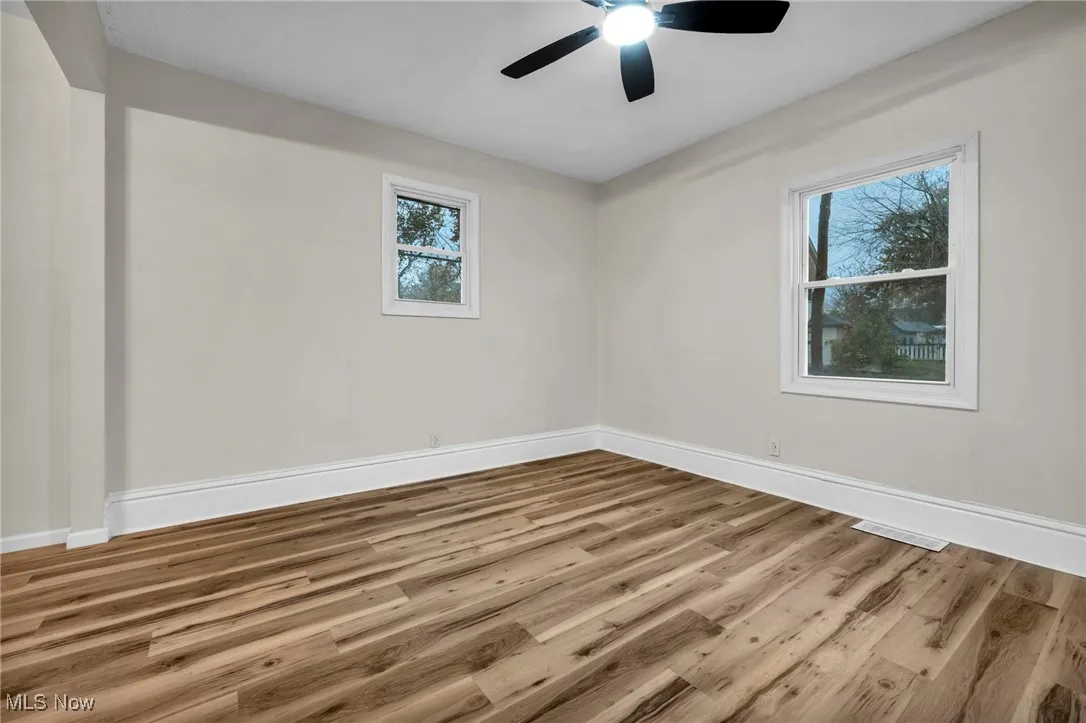 Spare room with wood finished floors and a ceiling fan