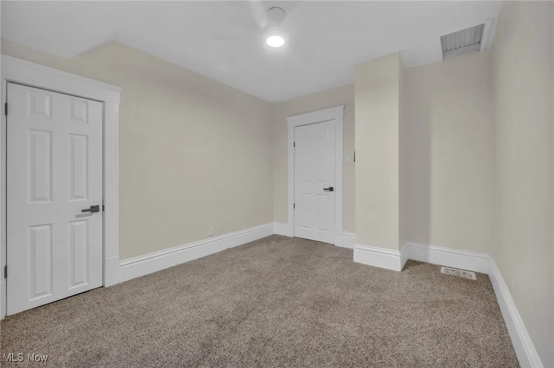 Carpeted spare room with baseboards and a ceiling fan