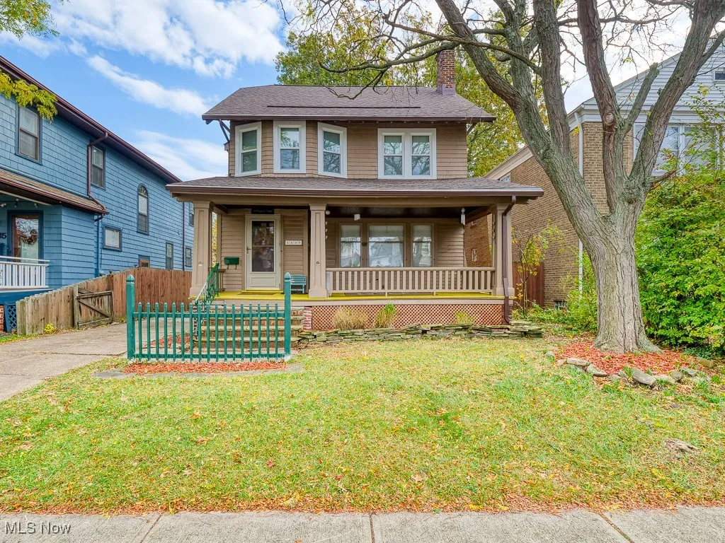 American foursquare style home featuring covered porch, a chimney, and a shingled roof
