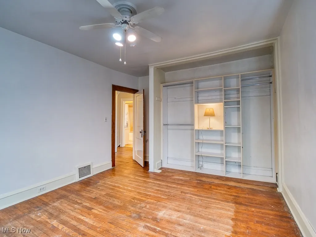 Unfurnished bedroom featuring light wood-type flooring, ceiling fan, and a closet