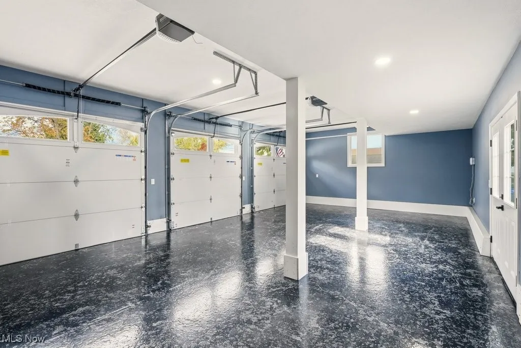 Garage featuring a garage door opener and recessed lighting