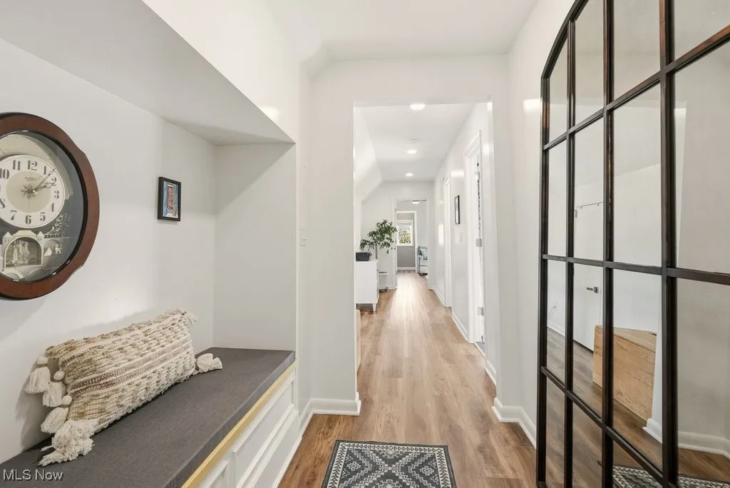 Corridor with light wood-type flooring and recessed lighting