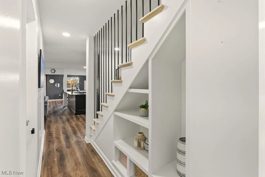 Corridor with dark wood finished floors and stairs