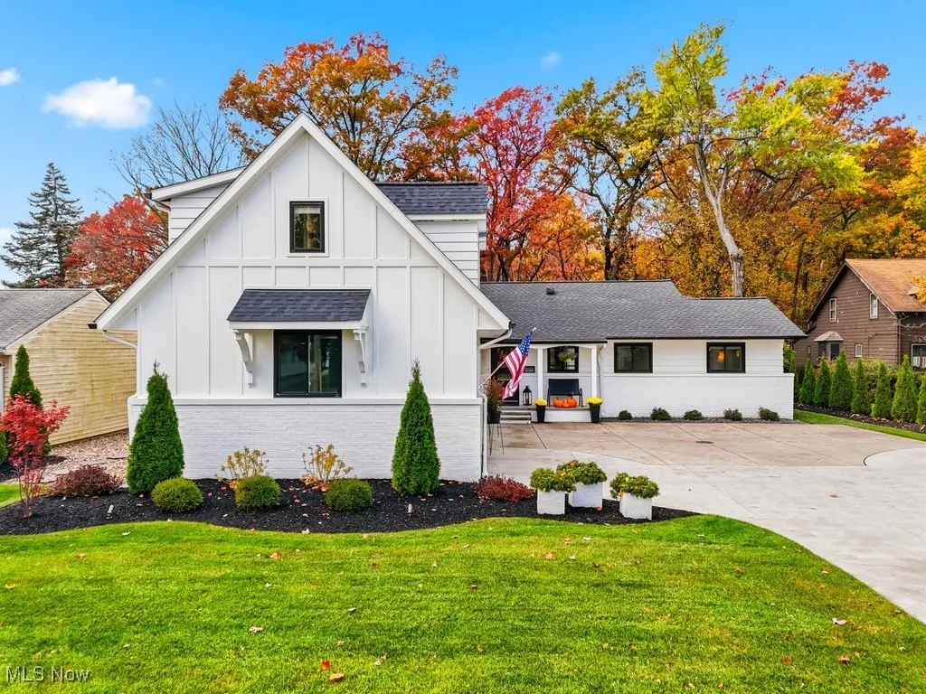 Modern farmhouse style home with board and batten siding, brick siding, a front lawn, and driveway