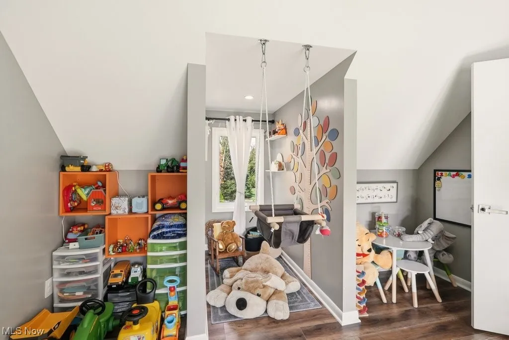 Playroom with lofted ceiling, dark wood finished floors, and recessed lighting