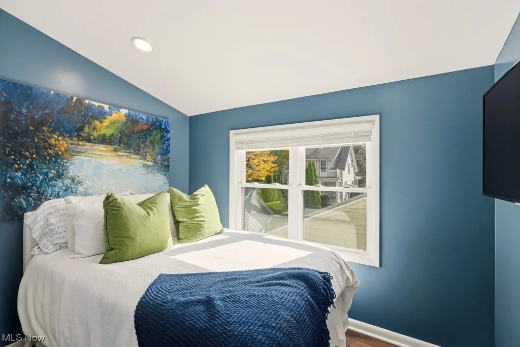 Bedroom with lofted ceiling, recessed lighting, and wood finished floors
