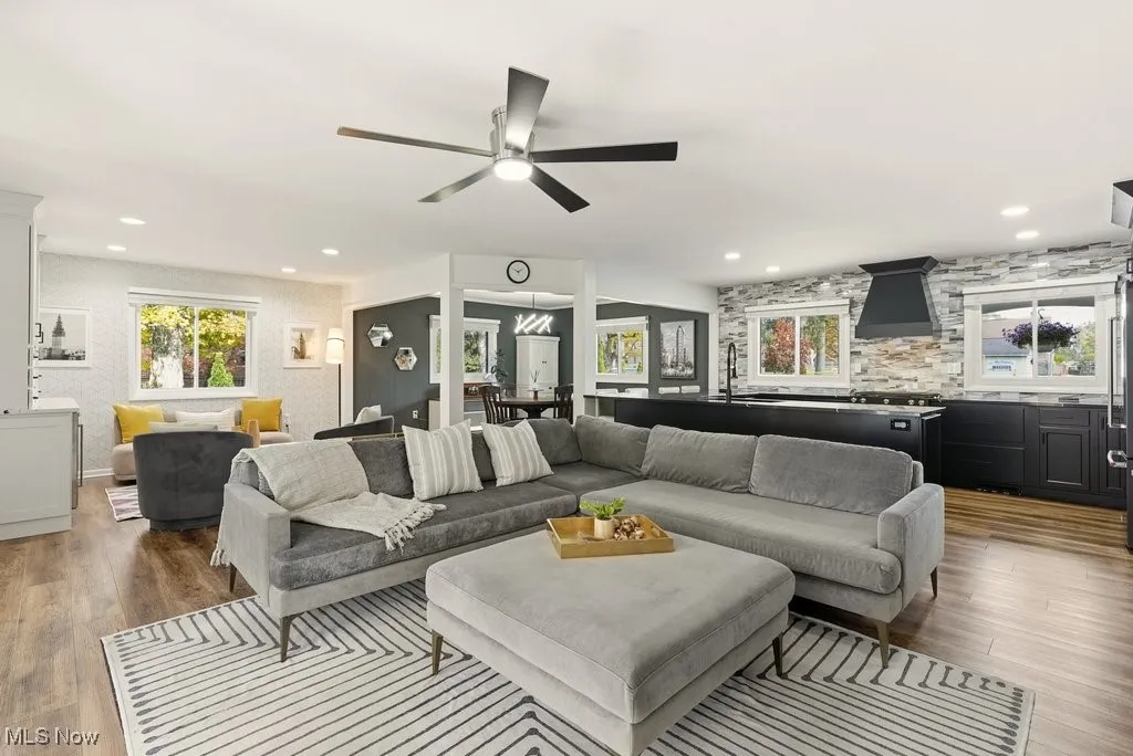 Living area featuring light wood-style floors, a ceiling fan, and recessed lighting