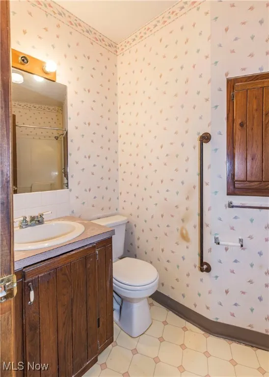 Bathroom with wallpapered walls and vanity