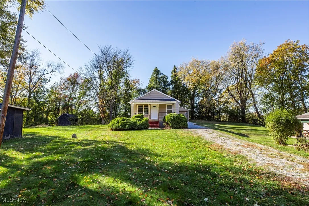 Bungalow-style house featuring a porch, a front yard, and driveway