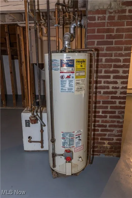 Utility room featuring gas water heater and a heating unit