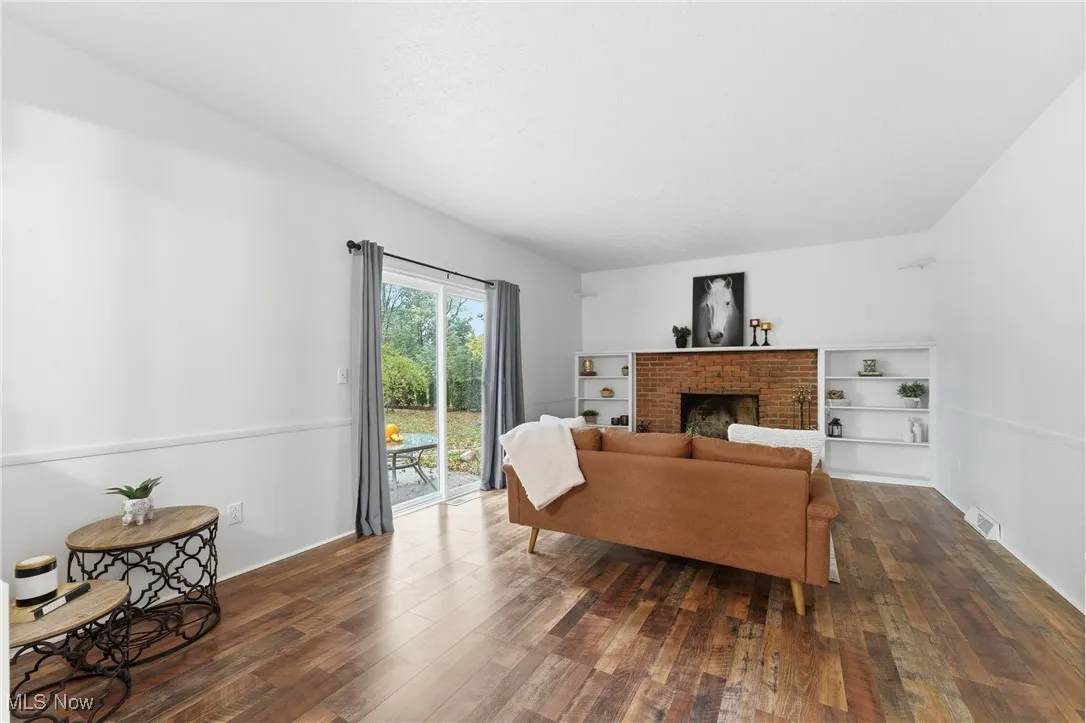 Living area with dark wood-style floors and a fireplace