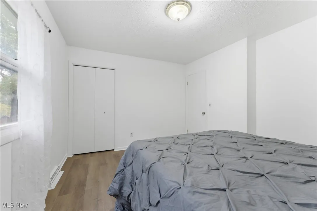 Bedroom featuring wood finished floors, a closet, and a textured ceiling