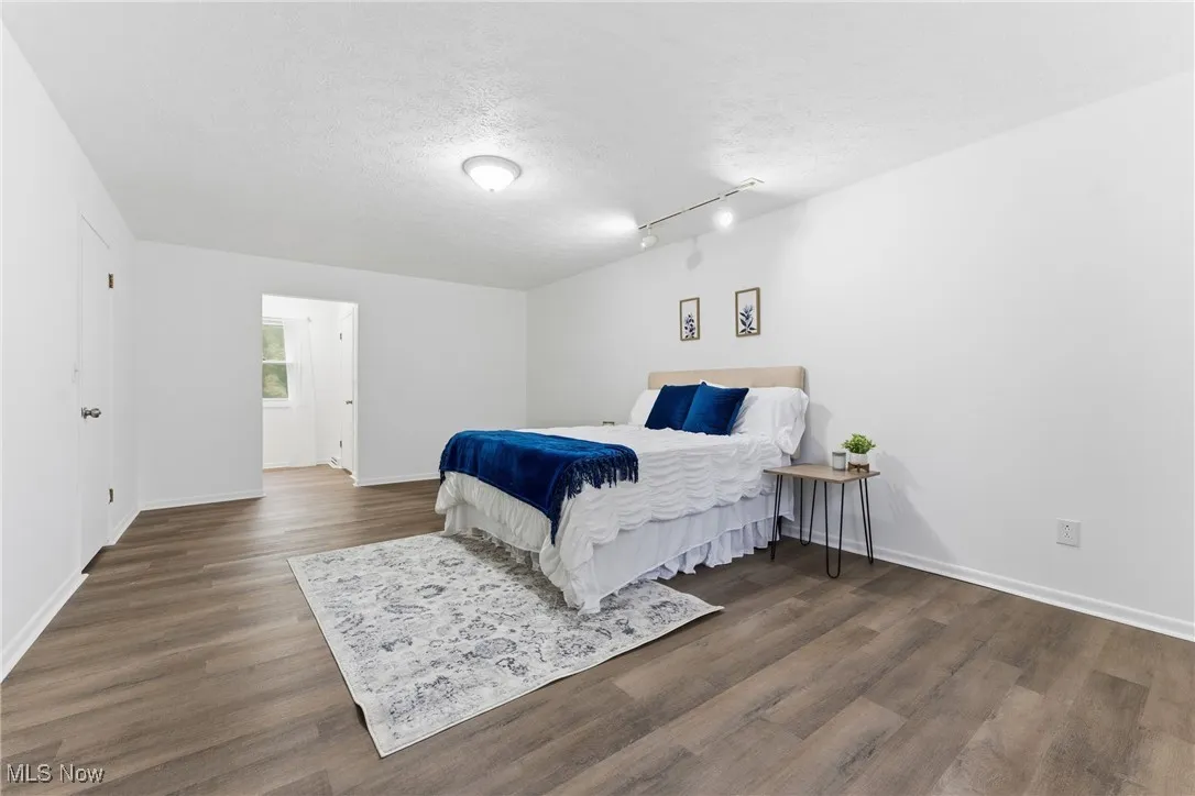 Bedroom featuring a textured ceiling and dark wood-style flooring