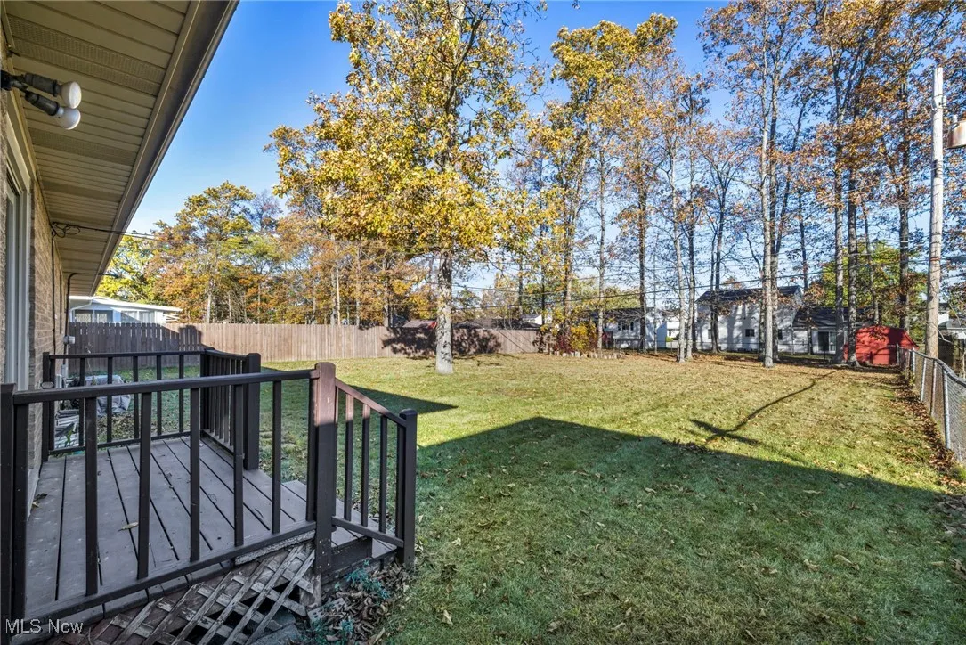 Fenced backyard featuring a deck