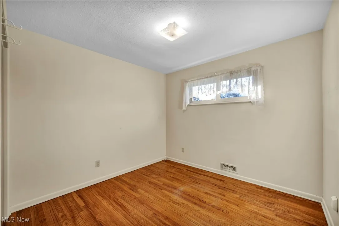 Spare room featuring wood finished floors and a textured ceiling