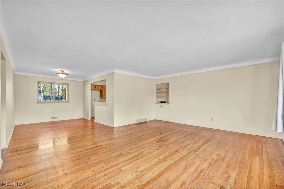 Spare room with light wood-style flooring and crown molding