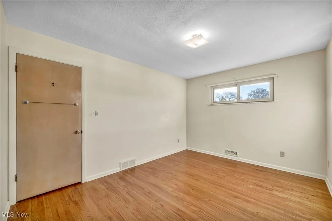 Unfurnished room featuring light wood-type flooring and a textured ceiling
