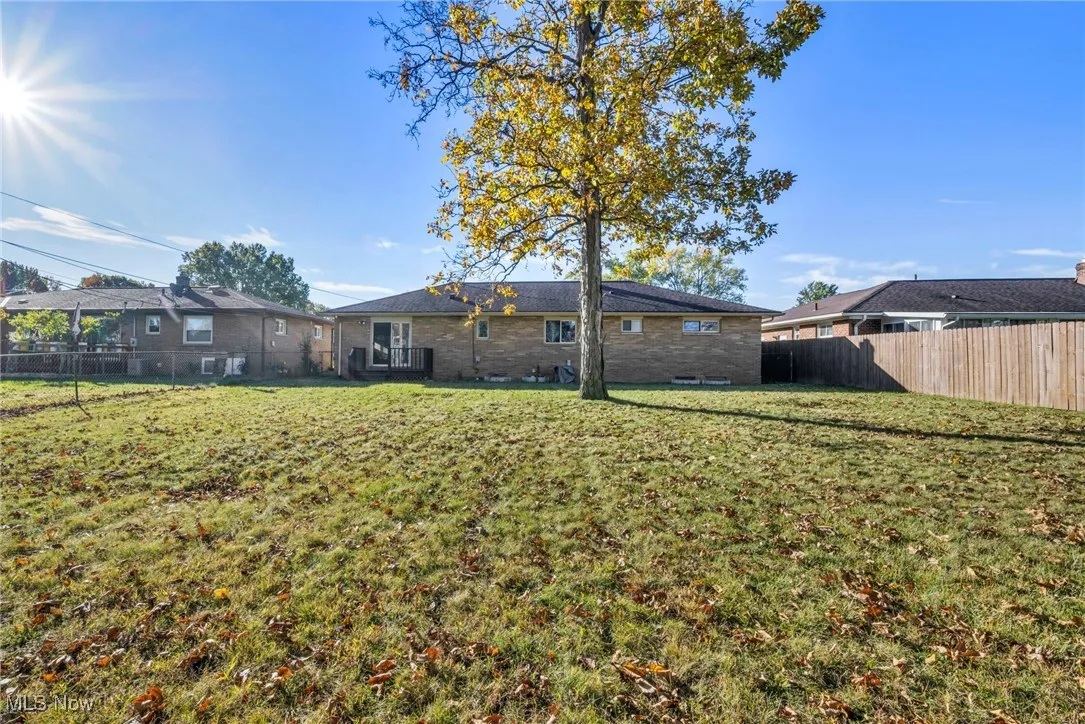 Rear view of property featuring a fenced backyard and brick siding