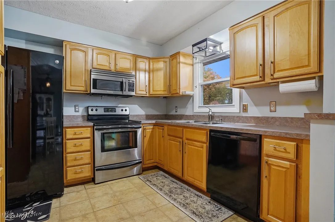 Kitchen featuring black appliances and a textured ceiling