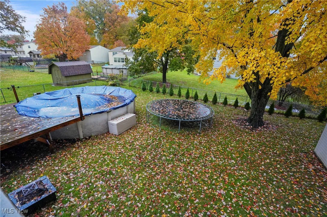 Fenced backyard with a trampoline and a storage shed