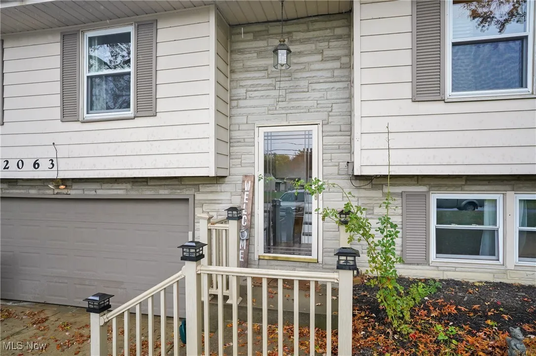 Property entrance featuring stone siding and an attached garage