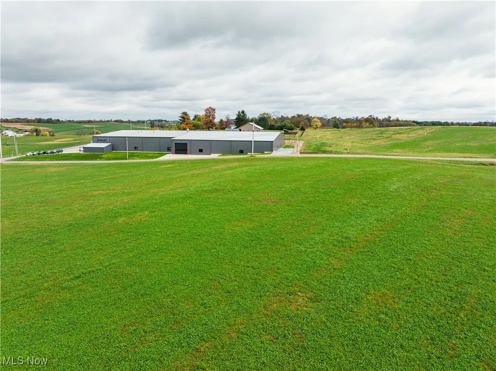 View of green lawn with an outbuilding and a rural view