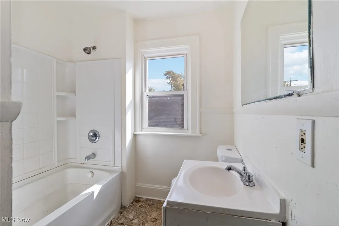 Full bath featuring plenty of natural light, vanity, and shower / washtub combination