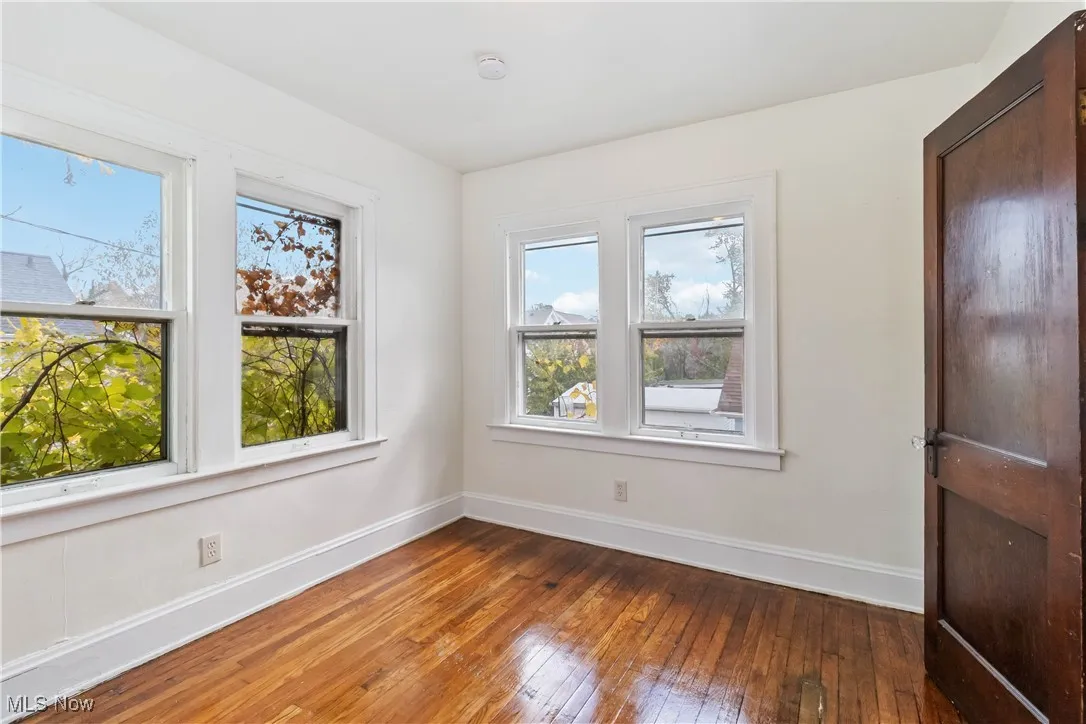 Unfurnished room featuring baseboards and wood-type flooring