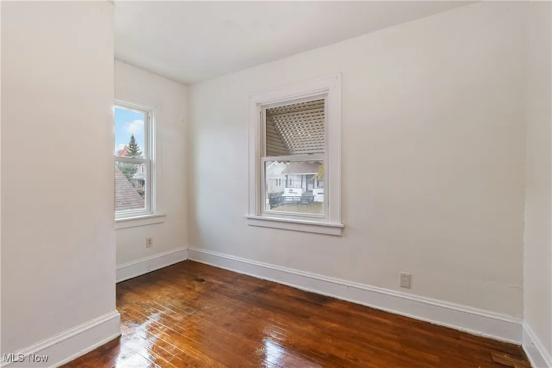 Empty room featuring baseboards and dark wood finished floors