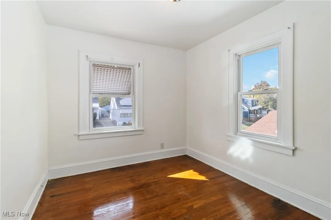 Empty room with dark wood-style floors and healthy amount of natural light