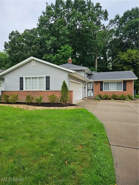 Split level home with a garage and a front lawn