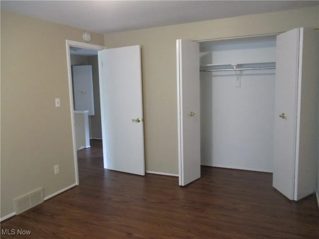 Featuring dark hardwood / wood-style flooring and a closet