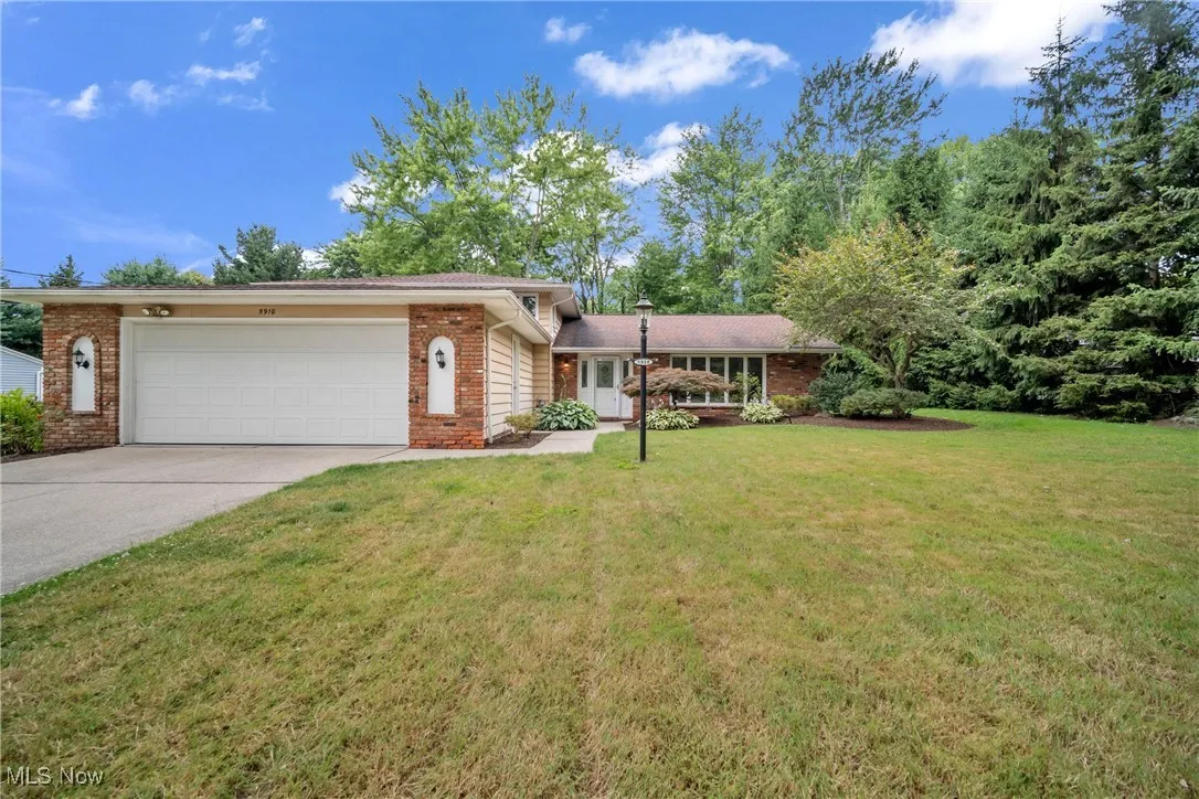 View of front of property with a garage and a front lawn