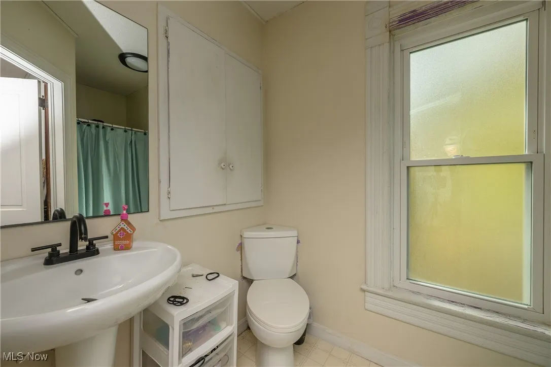 Bathroom featuring a shower with curtain and toilet