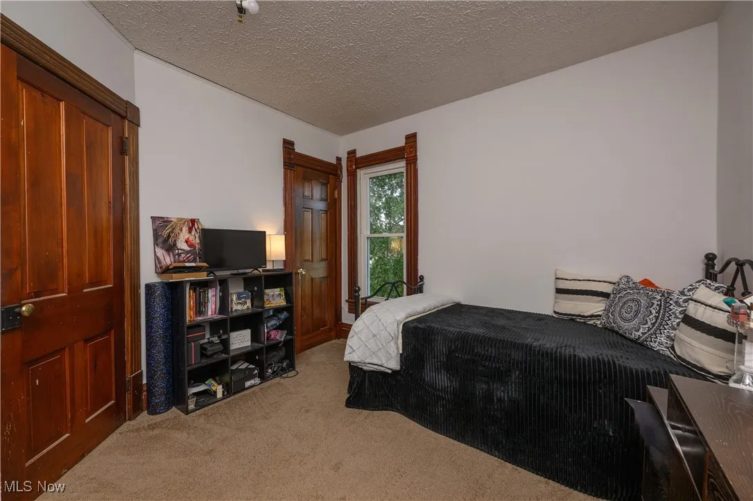 Bedroom featuring light carpet and a textured ceiling
