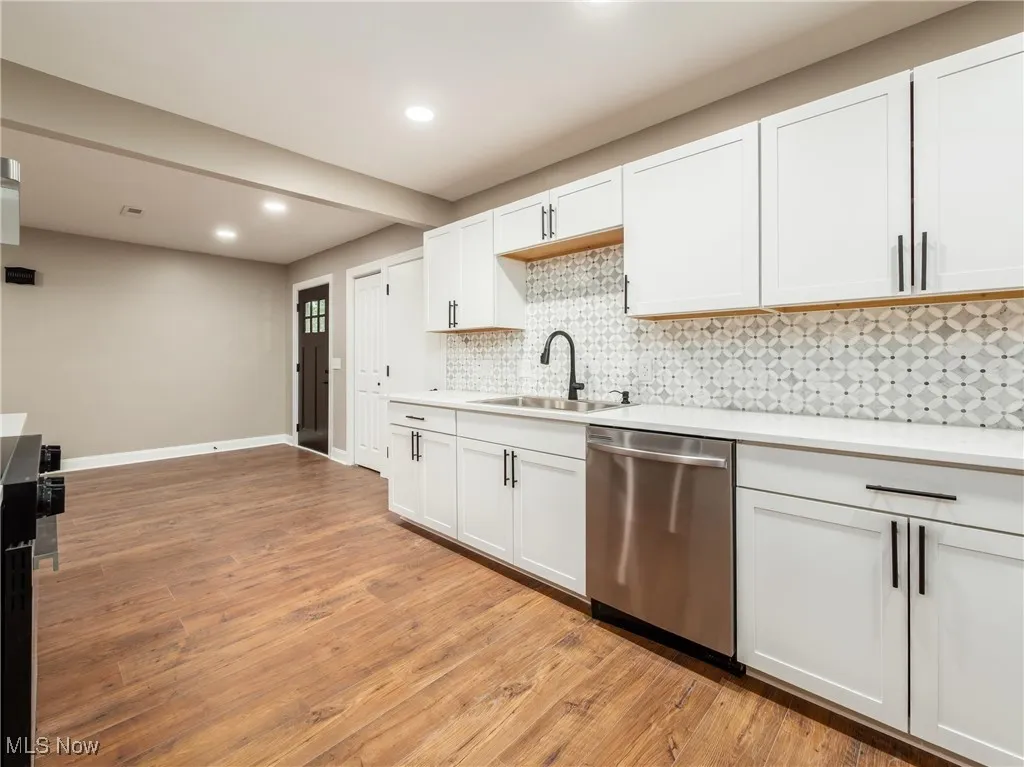 Kitchen with white cabinets, tasteful backsplash, dishwasher, and recessed lighting