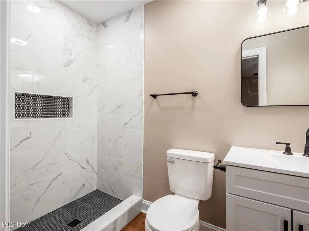 Full bathroom with a marble finish shower and vanity