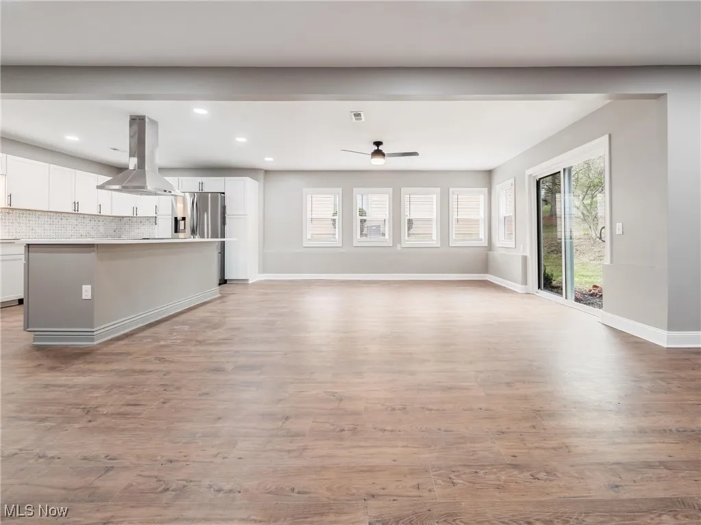 Unfurnished living room featuring light wood-type flooring, plenty of natural light, ceiling fan, and recessed lighting