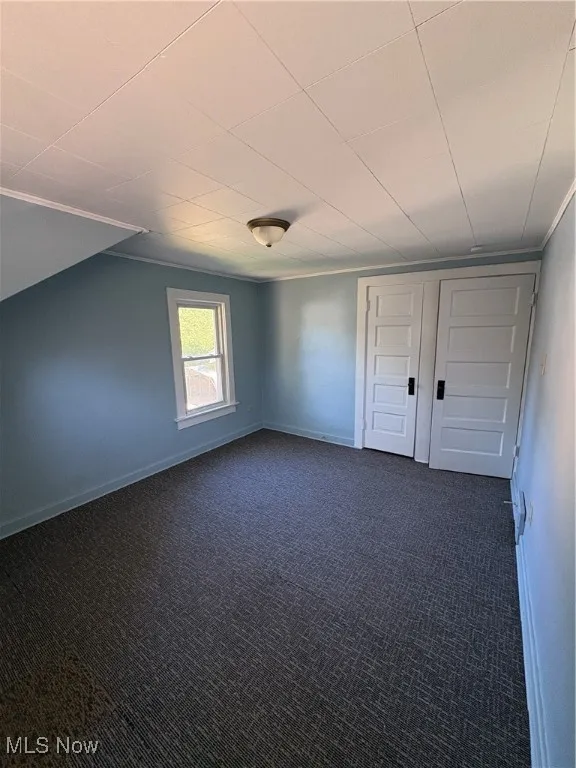 Bedroom featuring dark carpet and closet