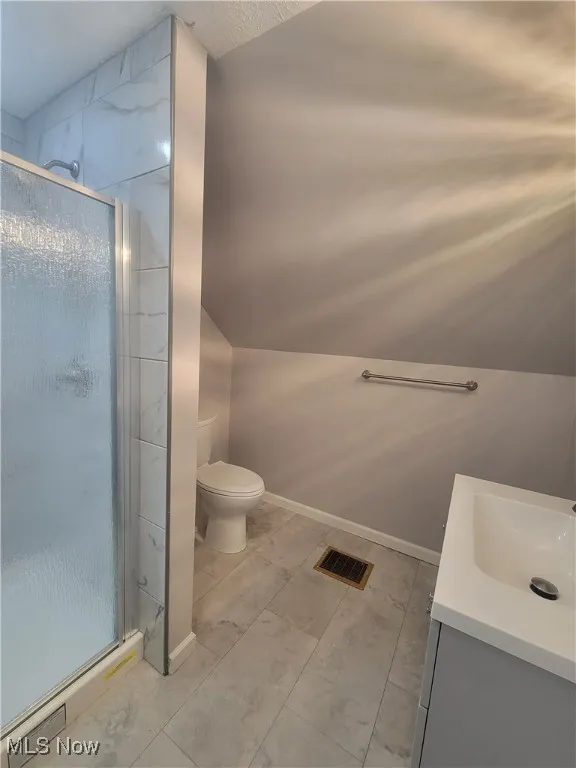 En-Suite Bathroom with lofted ceiling, vanity, and a stall shower