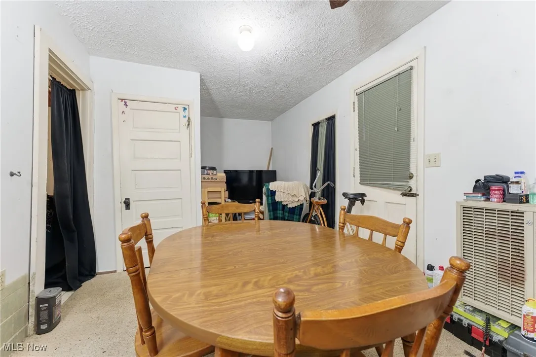 Dining space with a textured ceiling and speckled floor