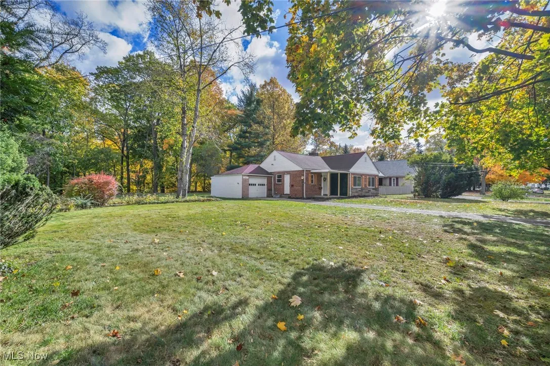 Ranch-style home featuring a front yard, brick siding, and an attached garage