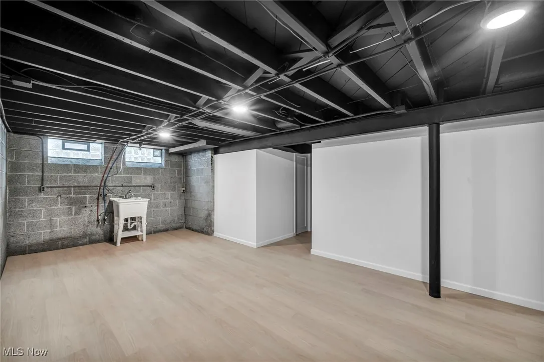 Basement with light wood-style floors and baseboards