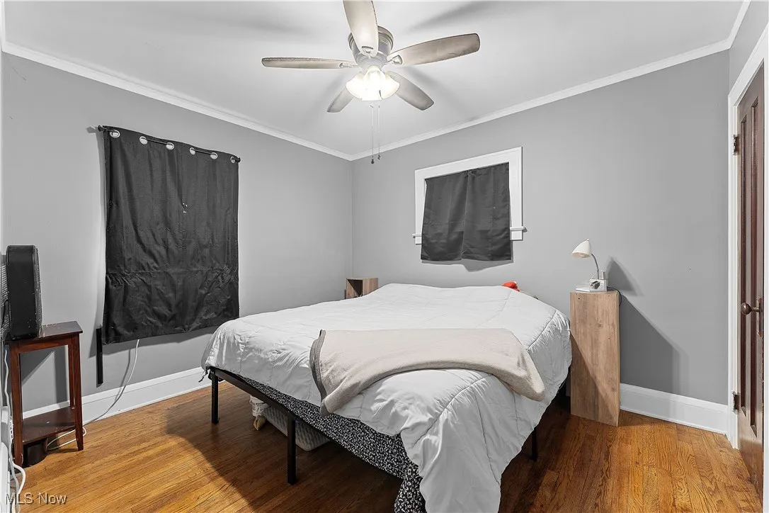 Bedroom featuring crown molding, light wood-style floors, and ceiling fan
