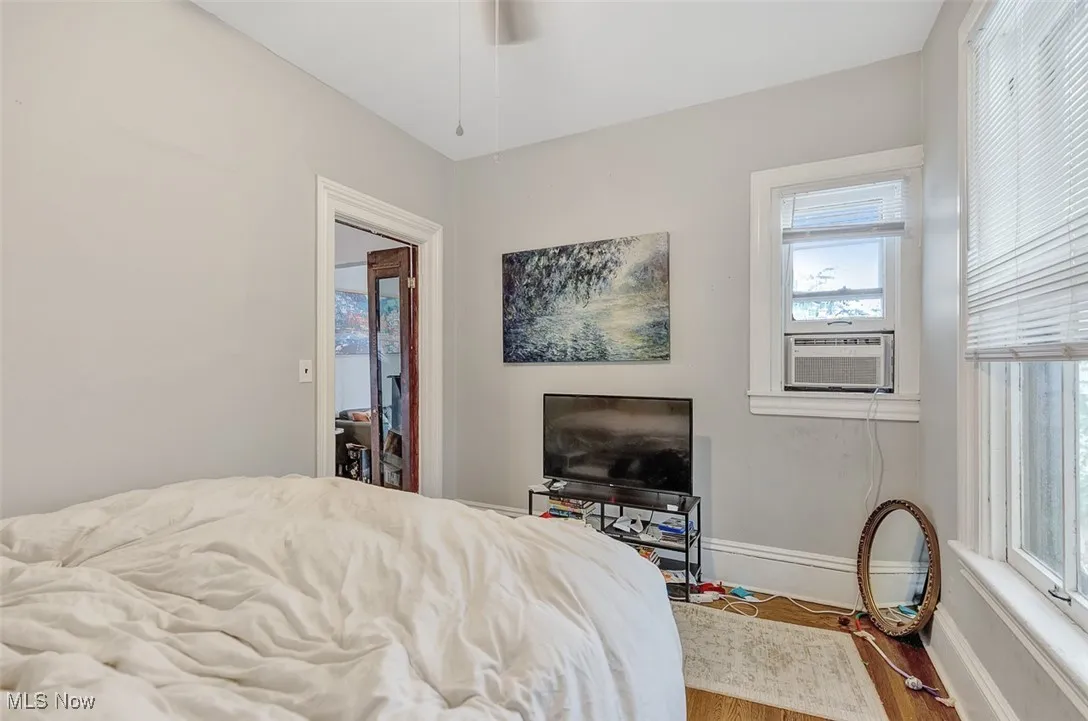 Bedroom featuring wood finished floors, access to exterior, and cooling unit
