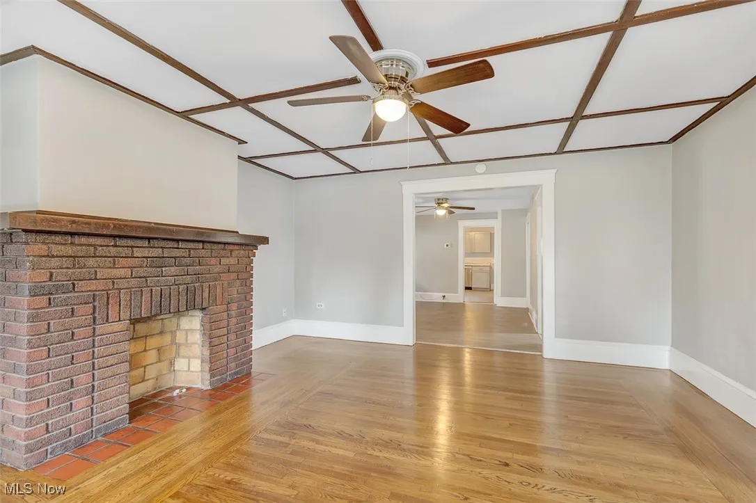 Unfurnished living room with light wood finished floors and a ceiling fan