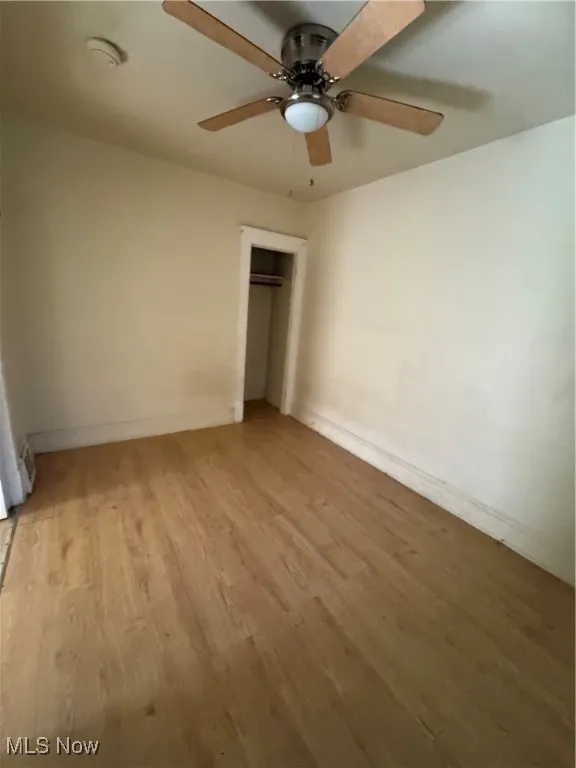 Unfurnished bedroom featuring light wood-style floors, ceiling fan, and a closet