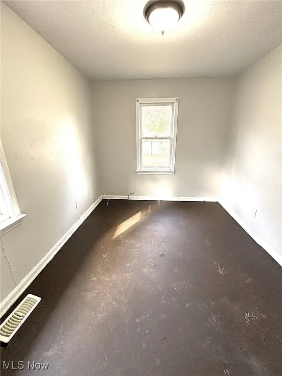 Empty room with concrete floors and a textured ceiling